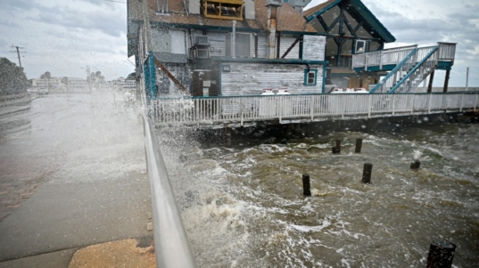Waves crash against a building ahead of the arrival of Hurricane Helene in Cedar Key, Florida, on September 26, 2024. - Parts of Florida face "unsurvivable" conditions when Hurricane Helene hits later Thursday, the US weather service said, warning that howling wind will drive destructive waves and storm surge as high as 20 feet (six meters) onto the low-lying coast. Residents heeded mass evacuation orders and fled ahead of the incoming hurricane -- projected to be one of the largest Gulf of Mexico storms in decades. (Photo by Miguel J. Rodriguez Carrillo / AFP)